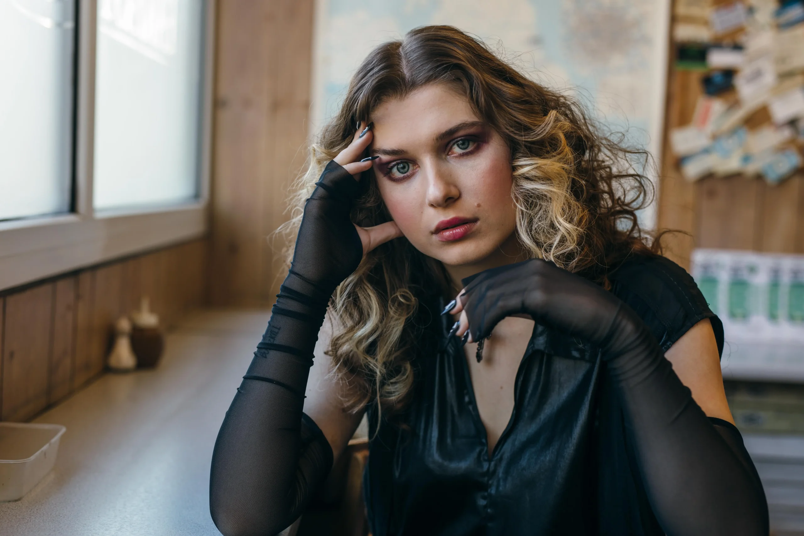 a fine art photograph of a fashionable female in her early 20's stoof in a deconstructed room with flaking walls behind her
